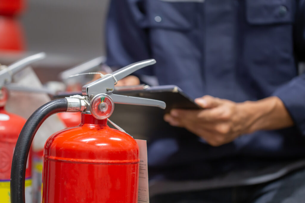 A man checking fire extinguisher after Fire Marshal Training Course