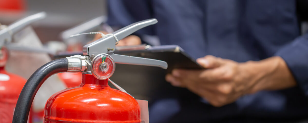 A man checking fire extinguisher after Fire Marshal Training Course