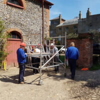Employees building Mobile Tower Scaffolding outside a business