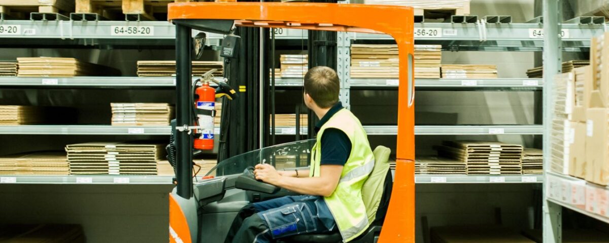 An employee using a reach forklift truck in a warehouse in a company in Norfolk