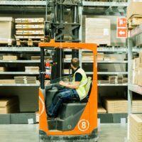 Reach Forklift Truck An employee using a reach forklift truck in a warehouse in a company in Norfolk