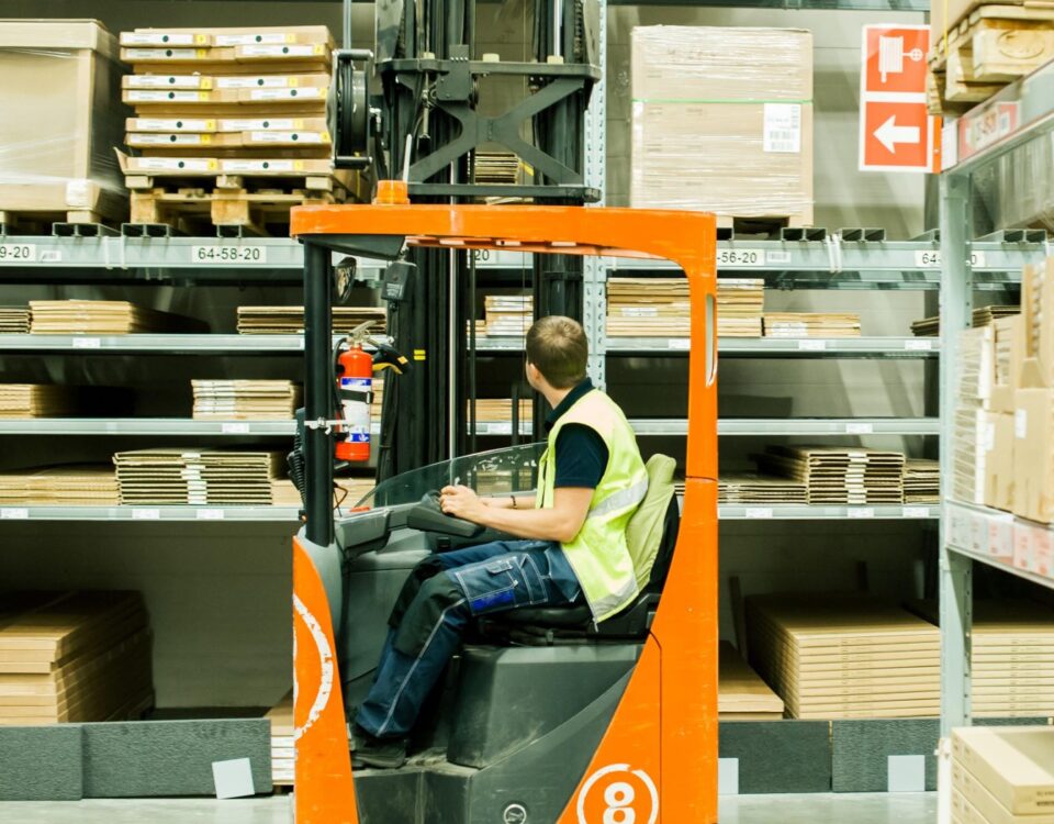 An employee using a reach forklift truck in a warehouse in a company in Norfolk