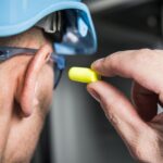 An employee using ear protection following a noise assessment