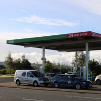 Petrol Station petrol station with vehicles refueling at the pumps under a clear sky.