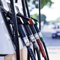 Fuel Pump Nozzles at a Gas Station Close-up of fuel pump nozzles in various colors at a gas station.