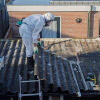 An employee in PPE working with Asbestos on a roof following Asbestos Awareness Training Course