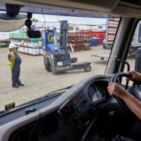 A employee in a yard directing traffic following Lorry Banksman Training
