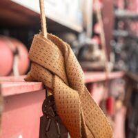 Brown woven lifting strap secured with a knot, used in safety and rigging applications.