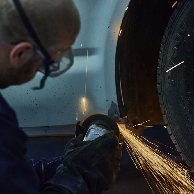 An employee using an abrasive wheels with protective PPE, following abrasive wheels training at Milne Safety.