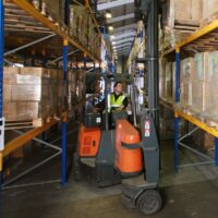 Pivot Steer Forklift Truck A man on a Pivot Steer Forklift Truck in a warehouse, completed training