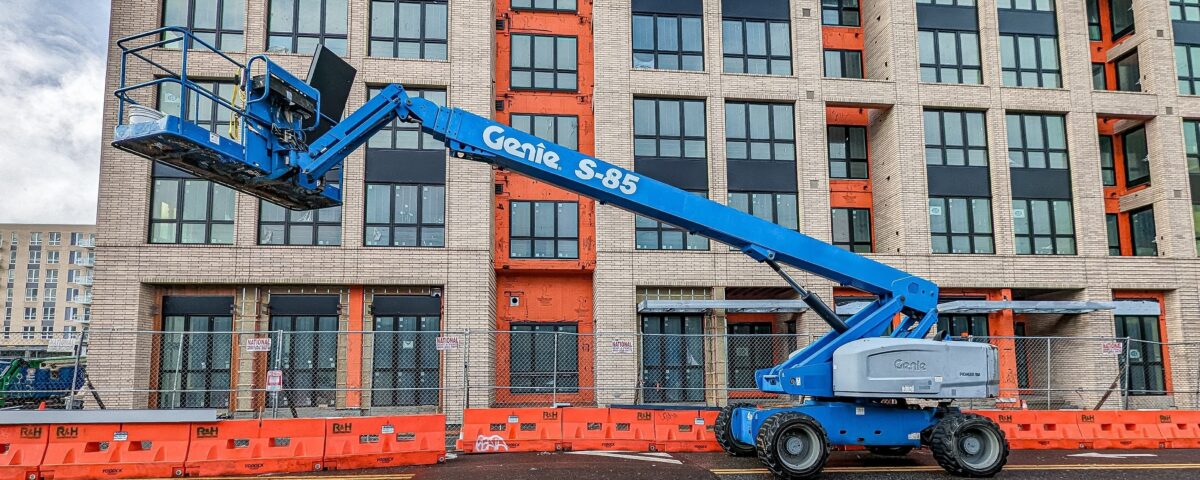 Blue Cherry Picker outside a office block, AITT accredited training is available from Milne Safety