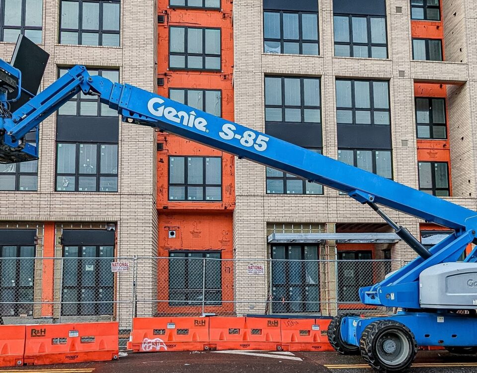 Blue Cherry Picker outside a office block, AITT accredited training is available from Milne Safety