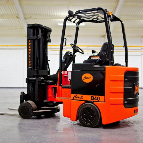 An orange and black Bendi B40 pivot steer forklift stands indoors with a raised mast and compact chassis.