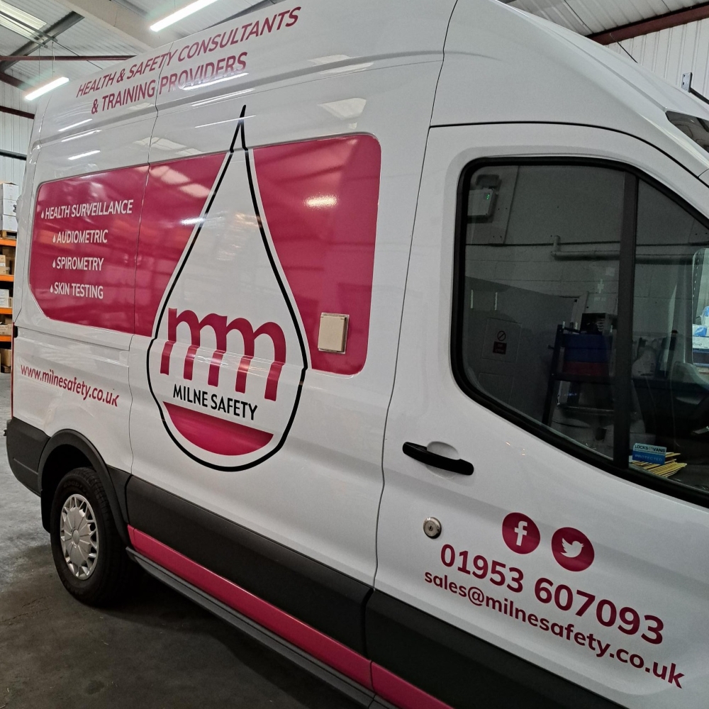 Milne Safety van in white and pink livery shows health surveillance, audiometric, spirometry and skin testing text.